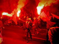 Participants light flares while threatening a journalist in Warsaw, Poland on 11 November, 2024. A march organized by far-right, nationalist...