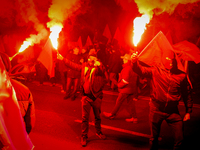 Participants light flares while threatening a journalist in Warsaw, Poland on 11 November, 2024. A march organized by far-right, nationalist...