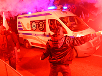 Paricipants light flares as an ambulance passes through the Independence Day march in Warsaw, Poland on 11 November, 2024. A march organized...