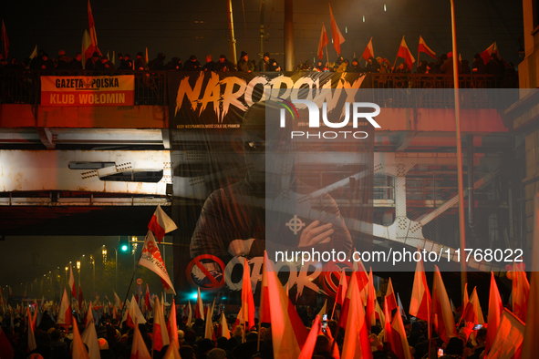 A large banner featuring a figure wearing a white supremacist symbol, a Celtic cross is seen during the Independence Day march in Warsaw, Po...