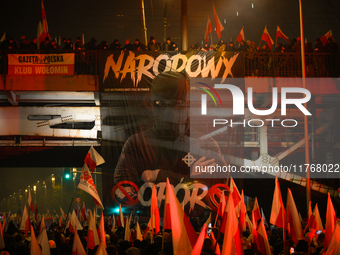 A large banner featuring a figure wearing a white supremacist symbol, a Celtic cross is seen during the Independence Day march in Warsaw, Po...