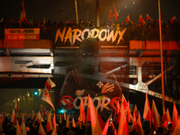 A large banner featuring a figure wearing a white supremacist symbol, a Celtic cross is seen during the Independence Day march in Warsaw, Po...