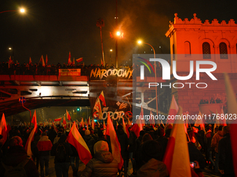 A large banner featuring a figure wearing a white supremacist symbol, a Celtic cross is seen during the Independence Day march in Warsaw, Po...