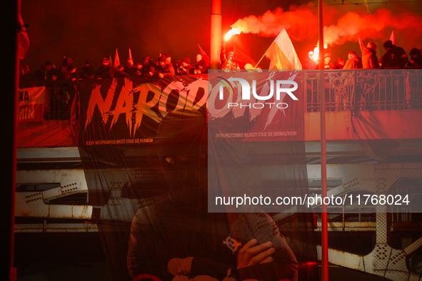 A large banner featuring a figure wearing a white supremacist symbol, a Celtic cross is seen during the Independence Day march in Warsaw, Po...