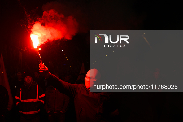 A man wearing a balaclava lights a flare in Warsaw, Poland on 11 November, 2024. A march organized by far-right, nationalist organizations w...