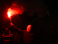 A man wearing a balaclava lights a flare in Warsaw, Poland on 11 November, 2024. A march organized by far-right, nationalist organizations w...