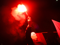 A man wearing a balaclava lights a flare in Warsaw, Poland on 11 November, 2024. A march organized by far-right, nationalist organizations w...