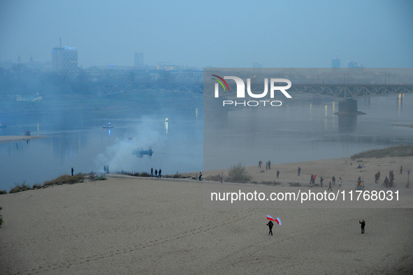 A man holds Polish flags on a beach on the Vistula river in Warsaw, Poland on 11 November, 2024. A march organized by far-right, nationalist...