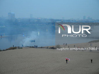 A man holds Polish flags on a beach on the Vistula river in Warsaw, Poland on 11 November, 2024. A march organized by far-right, nationalist...