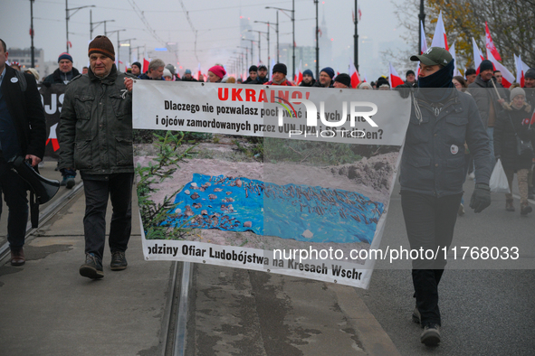 People hold a banner with text referring to Polish vicitms of the second Wolrd War Ukrainian Insurgent Army (OUN-UPA) in Warsaw, Poland on 1...