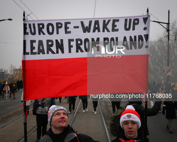 People hold a banner readubg ''Europe - Wake up! Learn from Poland!'' in Warsaw, Poland on 11 November, 2024. A march organized by far-right...