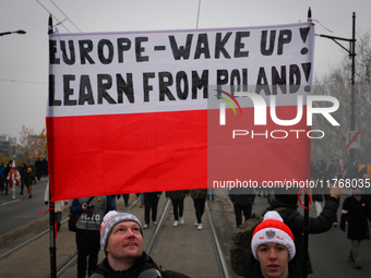 People hold a banner readubg ''Europe - Wake up! Learn from Poland!'' in Warsaw, Poland on 11 November, 2024. A march organized by far-right...