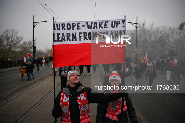 People hold a banner readubg ''Europe - Wake up! Learn from Poland!'' in Warsaw, Poland on 11 November, 2024. A march organized by far-right...