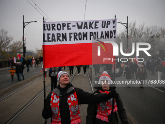 People hold a banner readubg ''Europe - Wake up! Learn from Poland!'' in Warsaw, Poland on 11 November, 2024. A march organized by far-right...