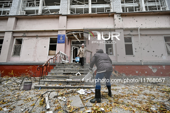 Women help with cleaning the sports complex of the Zaporizhzhia Polytechnic National University damaged by an overnight Russian air strike i...