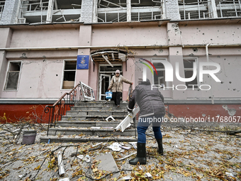 Women help with cleaning the sports complex of the Zaporizhzhia Polytechnic National University damaged by an overnight Russian air strike i...