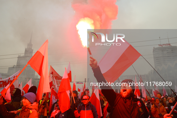 A man lights a flare during inedpendence day celebrations in Warsaw, Poland on 11 November, 2024. A march organized by far-right, nationalis...