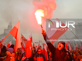 A man lights a flare during inedpendence day celebrations in Warsaw, Poland on 11 November, 2024. A march organized by far-right, nationalis...