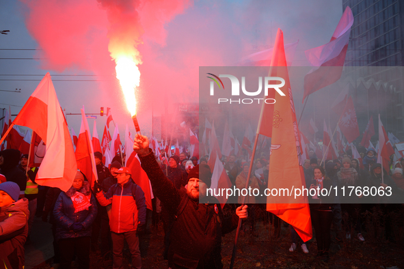 A man lights a flare during inedpendence day celebrations in Warsaw, Poland on 11 November, 2024. A march organized by far-right, nationalis...