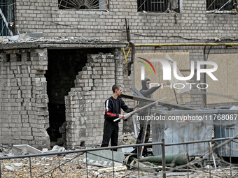 In Zaporizhzhia, Ukraine, on November 11, 2024, men throw debris into garbage containers outside a hostel where internally displaced persons...