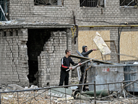 In Zaporizhzhia, Ukraine, on November 11, 2024, men throw debris into garbage containers outside a hostel where internally displaced persons...