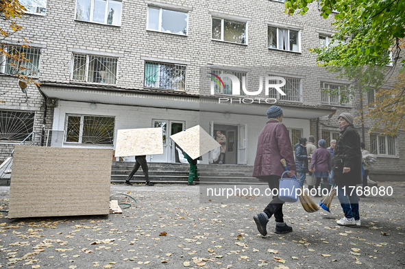 People repair a hostel where internally displaced persons live, damaged by an overnight Russian air strike in Zaporizhzhia, Ukraine, on Nove...