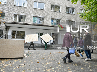 People repair a hostel where internally displaced persons live, damaged by an overnight Russian air strike in Zaporizhzhia, Ukraine, on Nove...