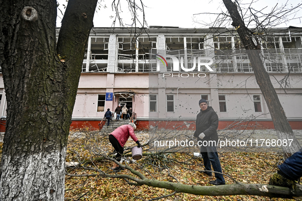 People remove debris from the premises of the sports complex of the Zaporizhzhia Polytechnic National University damaged by an overnight Rus...