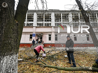 People remove debris from the premises of the sports complex of the Zaporizhzhia Polytechnic National University damaged by an overnight Rus...