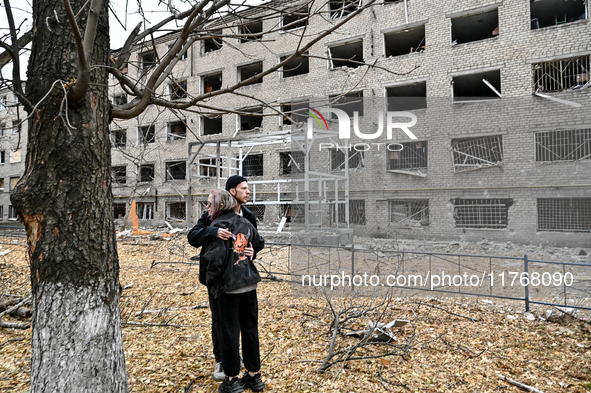 A man and woman hug each other outside a hostel where internally displaced persons live that is damaged by an overnight Russian air strike i...