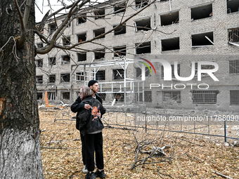 A man and woman hug each other outside a hostel where internally displaced persons live that is damaged by an overnight Russian air strike i...