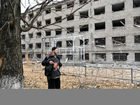 A man and woman hug each other outside a hostel where internally displaced persons live that is damaged by an overnight Russian air strike i...