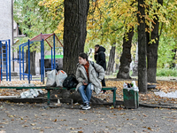 A woman with belongings sits on a bench outside a hostel where internally displaced persons live, which is damaged by an overnight Russian a...