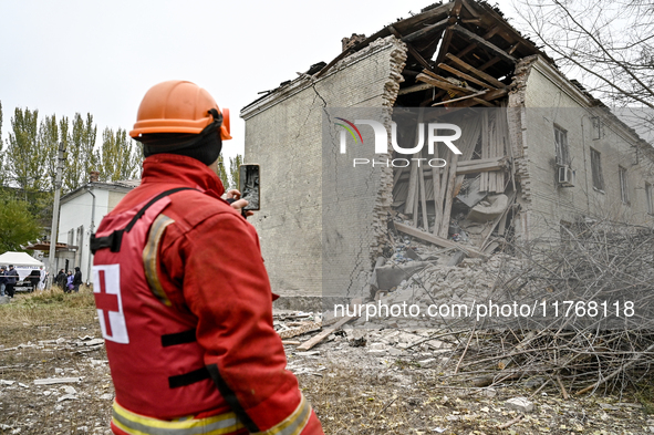 A volunteer looks at an apartment block where a child is injured after an overnight Russian air strike in Zaporizhzhia, Ukraine, on November...