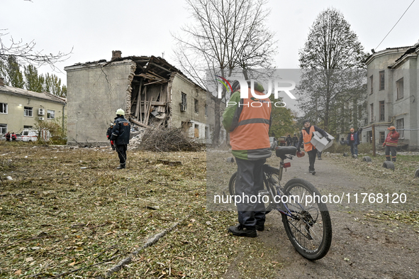 Rescuers and volunteers are outside an apartment block where a child is injured after an overnight Russian air strike in Zaporizhzhia, Ukrai...