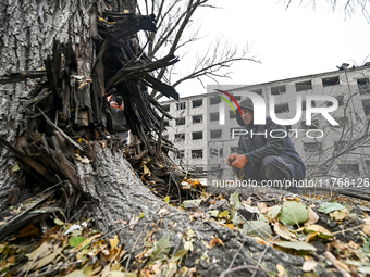 A man looks at a tree trunk outside the sports complex of the Zaporizhzhia Polytechnic National University, which is damaged by an overnight...