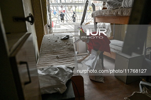 A woman sweeps the debris in a room of a hostel where internally displaced persons live, damaged by an overnight Russian air strike in Zapor...