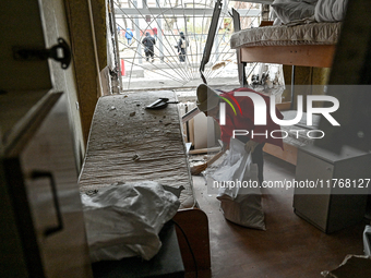 A woman sweeps the debris in a room of a hostel where internally displaced persons live, damaged by an overnight Russian air strike in Zapor...