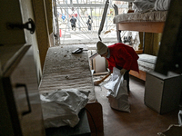 A woman sweeps the debris in a room of a hostel where internally displaced persons live, damaged by an overnight Russian air strike in Zapor...