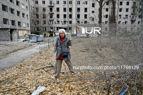 A woman captures the consequence of an overnight Russian air strike with a smartphone in the yard of a hostel where internally displaced per...