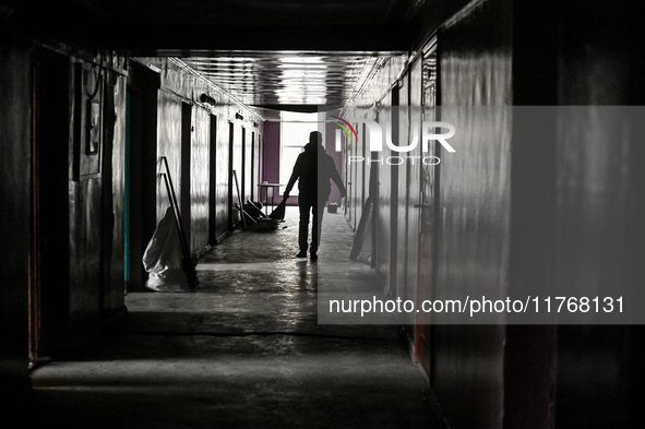 A woman with a broom walks along a corridor in a hostel where internally displaced persons live that is damaged by an overnight Russian air...