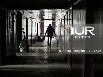 A woman with a broom walks along a corridor in a hostel where internally displaced persons live that is damaged by an overnight Russian air...