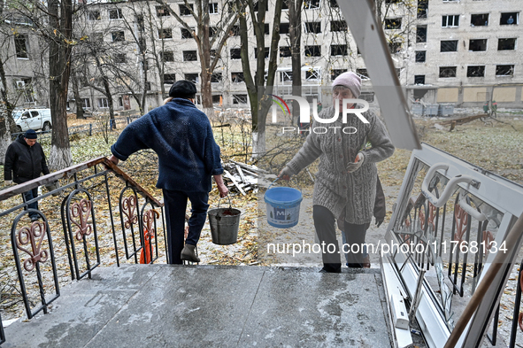 Women help with cleaning the sports complex of the Zaporizhzhia Polytechnic National University damaged by an overnight Russian air strike i...