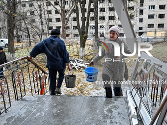 Women help with cleaning the sports complex of the Zaporizhzhia Polytechnic National University damaged by an overnight Russian air strike i...