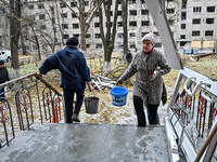 Women help with cleaning the sports complex of the Zaporizhzhia Polytechnic National University damaged by an overnight Russian air strike i...