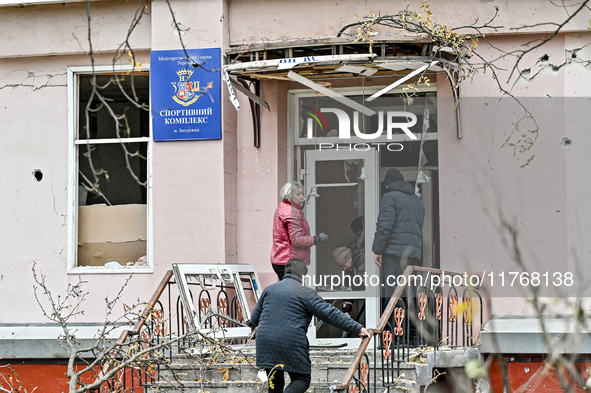 People clean the premises of the sports complex of the Zaporizhzhia Polytechnic National University damaged by an overnight Russian air stri...