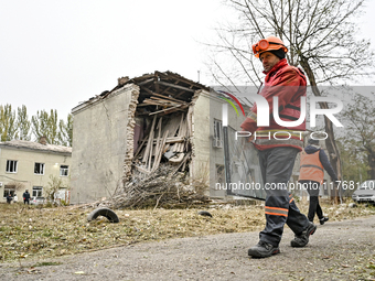 A volunteer carries a window pane past an apartment block where a child is injured after an overnight Russian air strike in Zaporizhzhia, so...