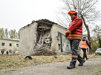 A volunteer carries a window pane past an apartment block where a child is injured after an overnight Russian air strike in Zaporizhzhia, so...