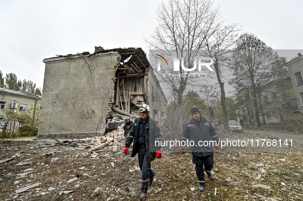 Rescuers pick up branches brought down by a shock wave outside an apartment block where a child is injured after an overnight Russian air st...