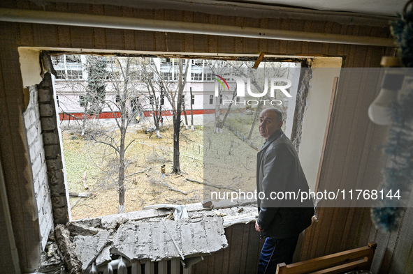 A man stands in front of a knocked-out window in a room of a hostel where internally displaced persons live, damaged by an overnight Russian...